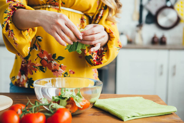 Young cute pregnant girl preparing vegetable salad in the kitchen. The concept of healthy eating. Toning. - Photo, Image