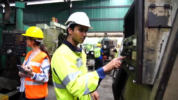 Zaměstnanci nebo technici kontrolují obsluhu starého stroje pomocí dálkového ovládání. - Záběry, video