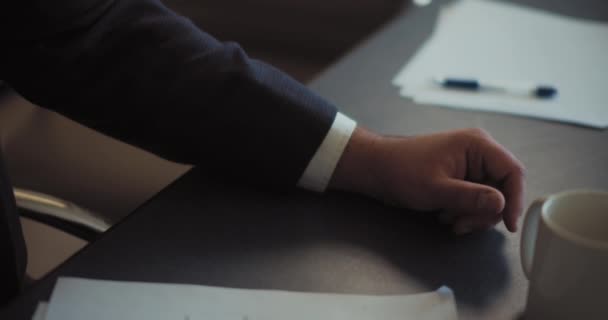 Hand van een man in een pak liggend op tafel. Zakelijke bijeenkomst concept. Close up, slow motion, ondiepe scherptediepte. - Video