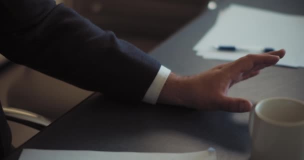 Hand of a man in a suit lying on the table. Business meeting concept. Close up, slow motion, shallow depth of field. - Footage, Video