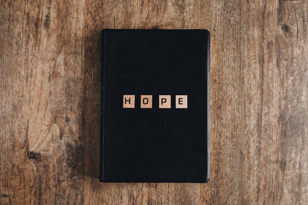 Esperança em cartas de bloco em uma bíblia em uma mesa de madeira. - Foto, Imagem