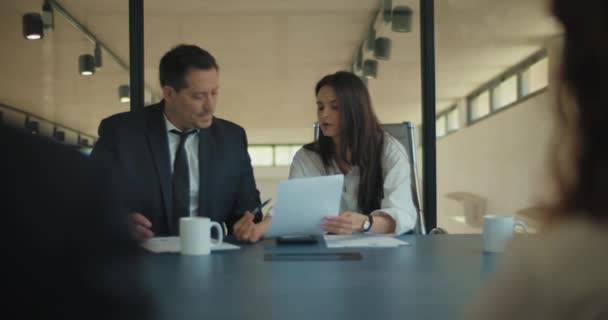 Femme et homme en costume discutent d'un projet avec leurs partenaires d'affaires dans la salle de réunion. Plan moyen, au ralenti. - Séquence, vidéo