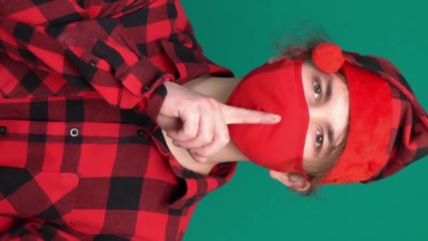 Segredo teen Santa chapéu dizendo hush estar quieto com o dedo nos lábios shhh gesto na máscara facial médica - Filmagem, Vídeo