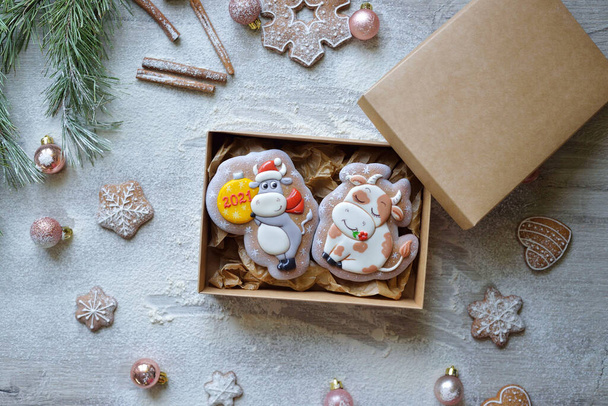 Noel zencefilli çörekler, 2021 yılının boğa Noel sembolleri şeklinde, bir el işi kutusunda eve teslim edilmek üzere paketlenmiştir. Yeni yıl yemek teslimatı konsepti. - Fotoğraf, Görsel