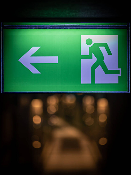 Green emergency exit sign in hotel showing the way to escape - Фото, изображение