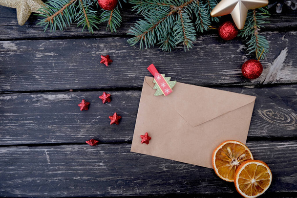 Em uma mesa de madeira há um envelope e uma composição de Ano Novo.  - Foto, Imagem