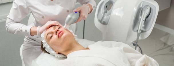 Ultraschallheben. Gesichtspflege. Nahaufnahme einer Frau, die in der Cosmetic Beauty Spa Clinic eine Behandlung mit Hydro-Mikrodermabrasion im Gesicht bekommt. Hydra Staubsauger. Peeling, Verjüngung und - Foto, Bild
