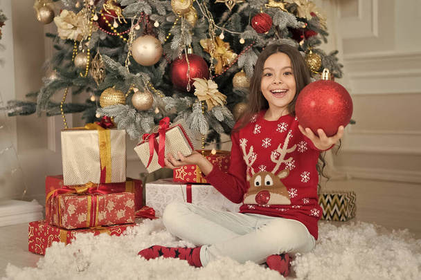 Experience beauty of Christmas season. Happy child hold glossy red ball decoration. Christmas tree decoration. Festive ornament and decoration. Holiday season decoration. Decorating tradition - Fotografie, Obrázek