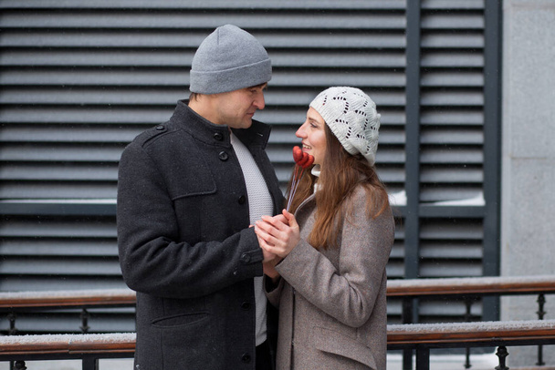 Giovane uomo sorpreso la sua ragazza con mazzo di cuori su bastone in città - Foto, immagini