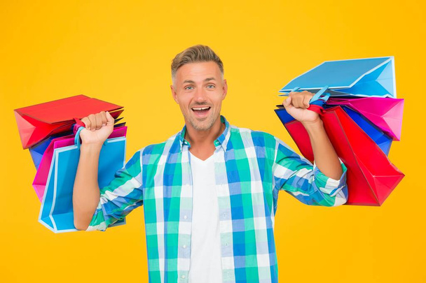 Home shopping. handsome cheerful man with paperbags. purchase in paper bags. guy hold gift. holiday flash sale and special offer. cyber monday in shop. customer. successful male shopping - Foto, Bild