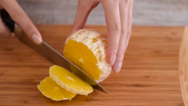 Zbliżenie ciętych owoców pomarańczy na drewnianej desce do krojenia. - Materiał filmowy, wideo