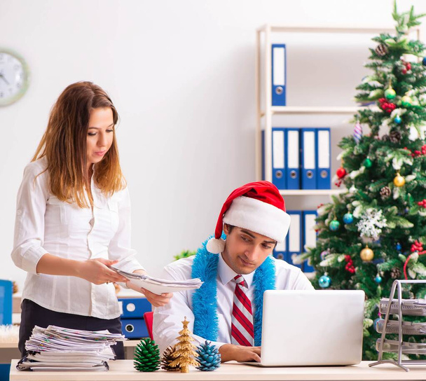 Man and woman working at the office on Cristmass eve - Foto, Imagen