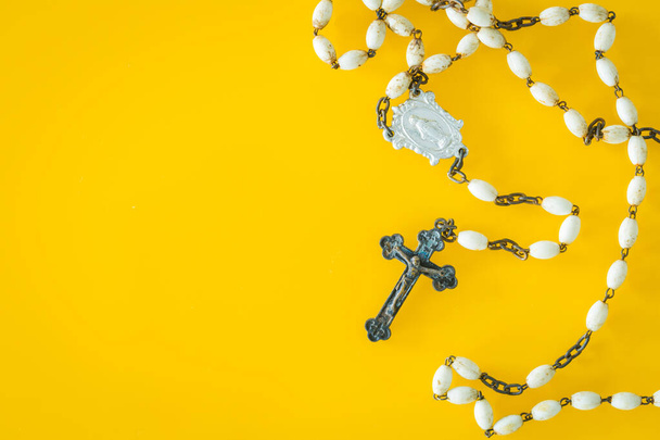 Christian rosary on a yellow background. Place for text - Photo, Image