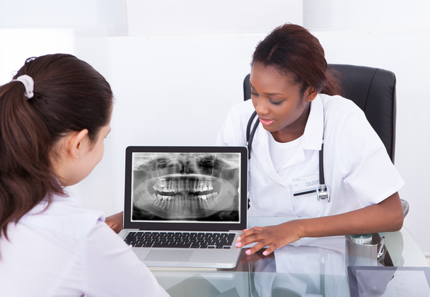 Dentist explaining jaw Xray to patient - Фото, зображення
