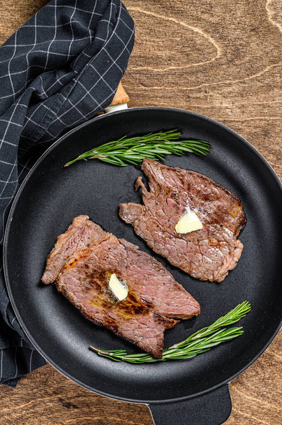 Grilled veal meat chop steak on a pan. Wooden background. Top view. - Photo, Image