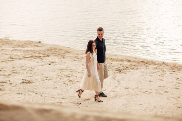 elegant and stylish woman and man in love are walking along the lake. Happy moments together. love story. - Foto, Imagen