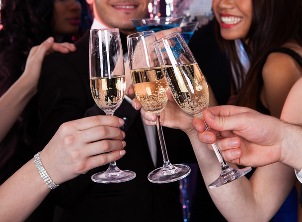 Friends Toasting Champagne At Nightclub - Foto, imagen