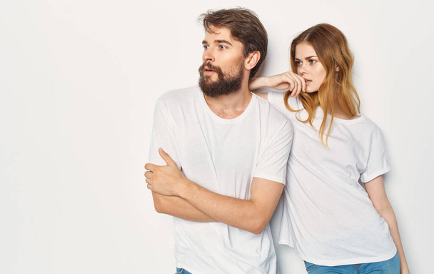 Egy fiatal pár áll egy fehér póló mellett közelről. - Fotó, kép