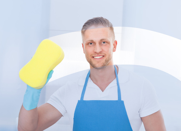 Male janitor using a sponge to clean a window - Fotografie, Obrázek