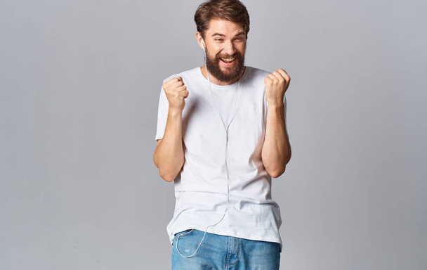 man in headphones dancing on a gray background and listening to music - Fotoğraf, Görsel