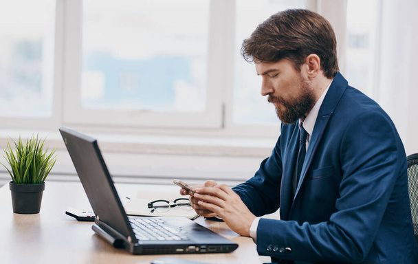 Спантеличений бізнесмен дивиться на ноутбук за столом в офісній роботі моделі офісу
 - Фото, зображення