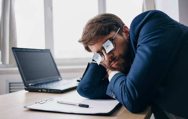 Бізнесмен спить на роботі в окулярах з листами паперу
 - Фото, зображення