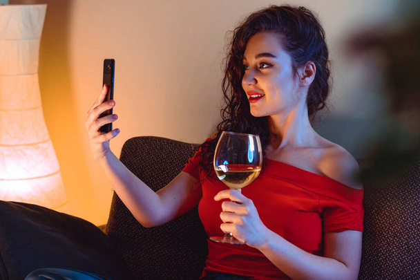 Жінка називає свого друга відео чатом і п'є вино. Онлайн дата, онлайн зустріч з друзями. Залишайся вдома. Соціальна відстань, ізоляція
 - Фото, зображення