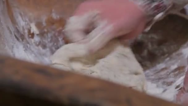 Un modo antico di fare il pane in campagna. Un uomo sta mescolando l'impasto con le mani in un piatto antico. - Filmati, video