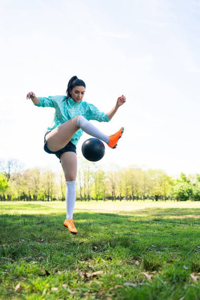 Fiatal nő gyakorló foci készségek labda. - Fotó, kép