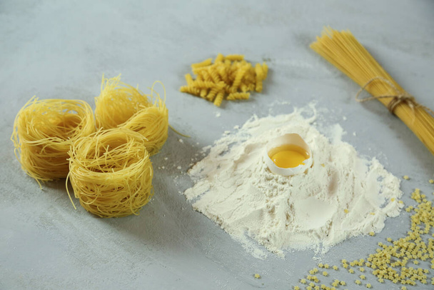 ingredients for homemade pasta. Food background: macaroni, spagetti, egg, flour - Foto, imagen