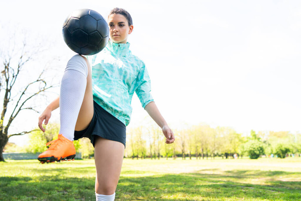 Young woman practicing soccer skills with ball. - Photo, image