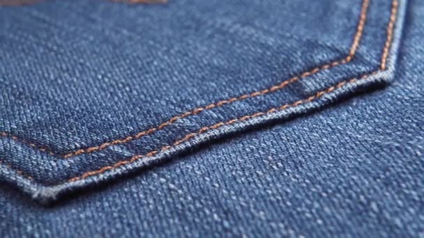 Indigo cotton denim jeans pocket with orange threads. Macro shot. Dolly Shot - Footage, Video