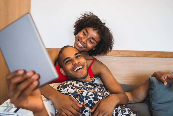 Young couple taking a selfie with digital tablet at home. - Foto, Imagen