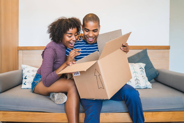 Young couple opening a package at home. - Foto, imagen