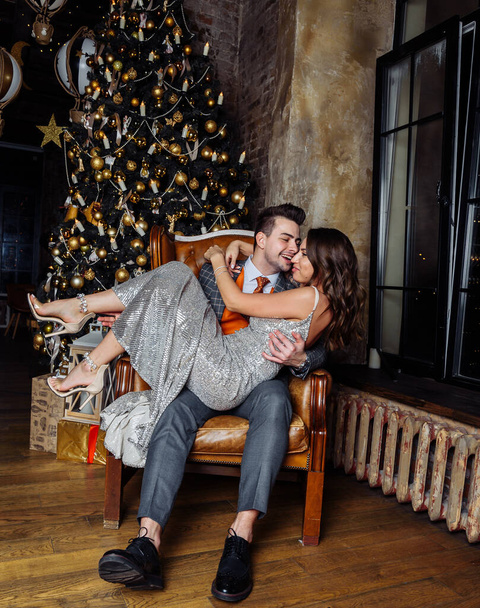 young couple newlyweds laugh rejoice having fun Christmas mood hug tenderness love kiss Christmas - Photo, Image