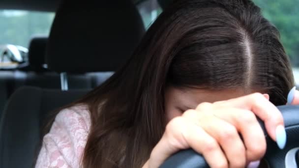 Θλιβερή και κουρασμένη γυναίκα που γέρνει το κεφάλι της στο τιμόνι, κλαίγοντας ενώ κάθεται στο αυτοκίνητο. - Πλάνα, βίντεο
