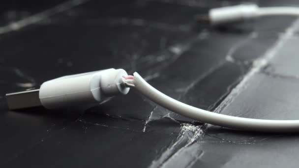 Arızalı USB şarj kablosu makro atışı. Beyaz hasarlı kablo grunge koyu arkaplan kapalı - Video, Çekim