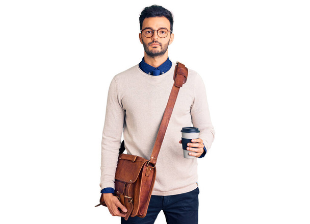 Mladý pohledný hispánec muž v kožené tašce a pití vzít kávu myšlení postoj a střízlivý výraz hledá sebevědomí  - Fotografie, Obrázek