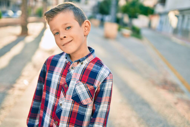 Adorable garçon caucasien souriant heureux debout à la ville. - Photo, image