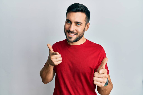 Young hispanic man wearing casual clothes pointing fingers to camera with happy and funny face. good energy and vibes.  - Fotó, kép