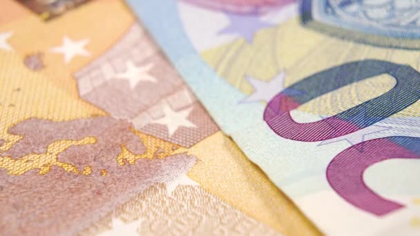 Una moneta in euro da vicino cade sulle banconote in valuta europea. Al rallentatore. Macro - Filmati, video
