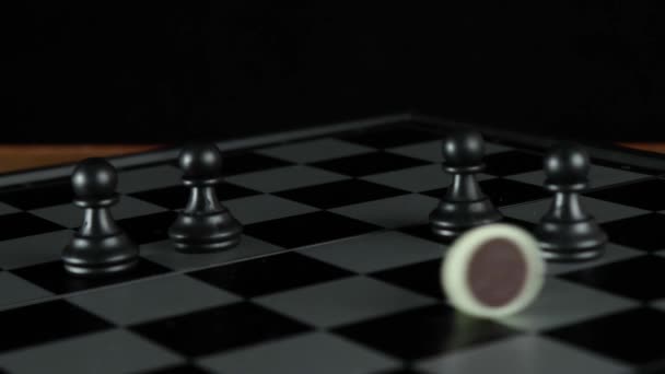 Vijf pionnen op een schaakbord. Een van hen is blank. - Video