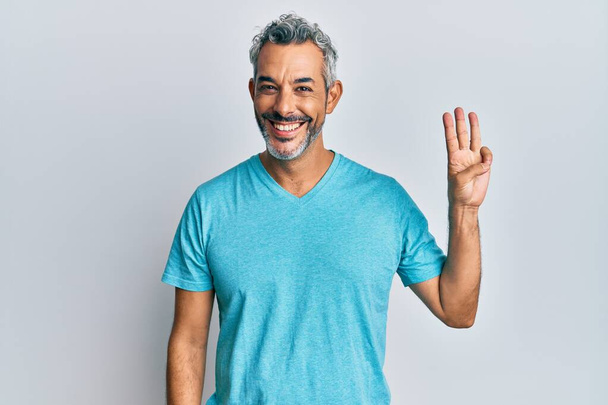 Hombre de pelo gris de mediana edad vistiendo ropa casual mostrando y señalando con los dedos número tres mientras sonríe confiado y feliz.  - Foto, Imagen