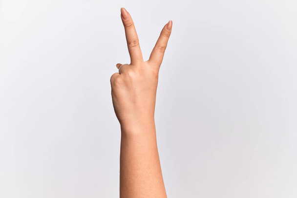 Käsi valkoihoinen nuori nainen laskee numero 2 osoittaa kaksi sormea, eleiden voitto ja voittaja symboli - Valokuva, kuva