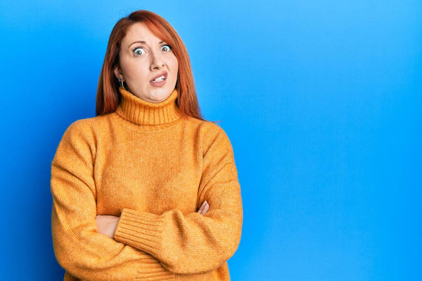 Beautiful redhead woman with arms crossed gesture in shock face, looking skeptical and sarcastic, surprised with open mouth  - Photo, Image
