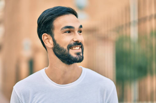 A fiatal spanyol férfi boldogan mosolyog a városban.. - Fotó, kép