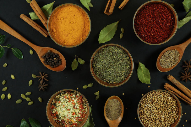 Wide variety spices and herbs on background of black table - Foto, Imagen