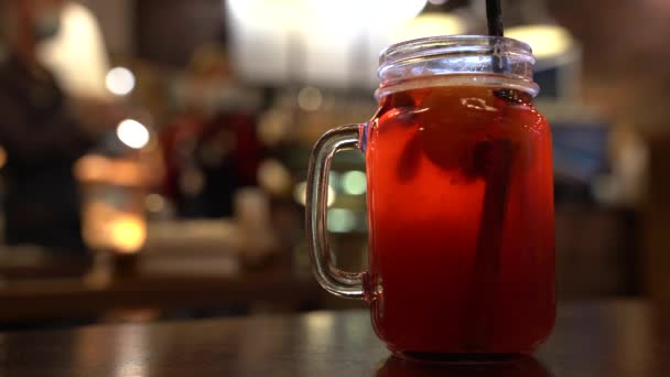 Kerstdrank rode niet-alcoholische glühwein met een rietje op de achtergrond van het cafe interieur, bestelling voor een, mengen met de stok - Video