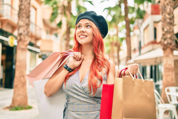 Młoda ruda dziewczyna nosi francuski styl trzymając torby na zakupy w mieście - Zdjęcie, obraz