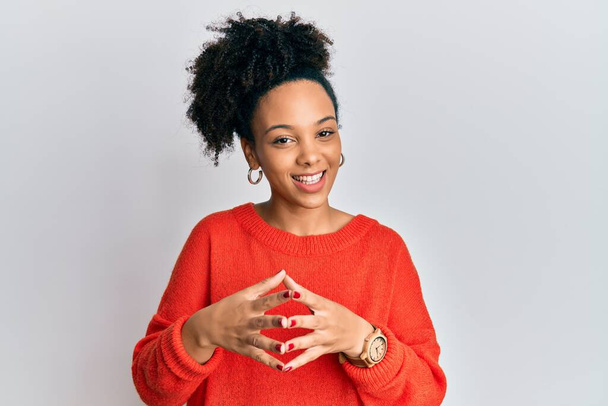 Jong Afrikaans Amerikaans meisje draagt casual kleding handen bij elkaar en vingers gekruist lachend ontspannen en vrolijk. succes en optimisme  - Foto, afbeelding